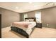 Cozy main bedroom with a large bed, side tables, neutral carpet, and natural light from two windows at 12234 W Saratoga Ave, Morrison, CO 80465