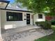 Charming front exterior with modern door, white paint, stone accents, and lush green foliage at 2836 S Fenton St, Denver, CO 80227
