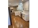 Well-lit kitchen with white cabinets, quartz counters and stainless steel appliances overlooking a living area at 2836 S Fenton St, Denver, CO 80227