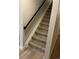 Carpeted stairs with a black handrail and white trim. Stair coverings may need to be removed at 2836 S Fenton St, Denver, CO 80227