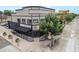 Corner view of grey brick building with covered patio, trees, and crosswalk at 474 N Inca St, Denver, CO 80204