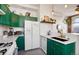 Bright kitchen features green cabinetry, white countertops, stainless steel appliances, and a modern sink at 474 N Inca St, Denver, CO 80204