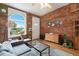 Inviting living room features exposed brick wall, large window, and a cozy seating area at 474 N Inca St, Denver, CO 80204