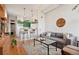A cozy living room features an open kitchen with green cabinets, exposed brick, and hardwood floors at 474 N Inca St, Denver, CO 80204