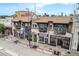 View of a mixed use brick building with storefronts and apartments on a tree lined city street at 474 N Inca St, Denver, CO 80204