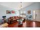 Bright living room with hardwood floors, a comfortable leather sofa, and a large window offering neighborhood views at 4931 S Danube St, Aurora, CO 80015