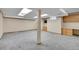 Spacious basement with carpet, support beam, and built-in cabinets for storage at 10222 W Ida Ave # 237, Littleton, CO 80127