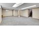 Open basement area with neutral carpet, column support, and access to the upper level at 10222 W Ida Ave # 237, Littleton, CO 80127