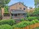 Back exterior view of home showing fenced-in deck and mature trees at 10222 W Ida Ave # 237, Littleton, CO 80127