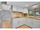 Well-lit kitchen featuring stone countertops, stainless steel appliances, and white cabinets at 10222 W Ida Ave # 237, Littleton, CO 80127