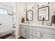 Double vanity bathroom with white cabinets and a large mirror at 528 Nesting Eagles Way, Berthoud, CO 80513