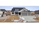 Gray exterior two-story house with stone accents, three-car garage, and landscaped yard at 528 Nesting Eagles Way, Berthoud, CO 80513