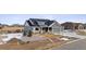 Two-story home with gray siding, stone accents, and a three car garage at 528 Nesting Eagles Way, Berthoud, CO 80513