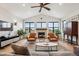 Bright living room with hardwood floors, fireplace, and ceiling fan at 528 Nesting Eagles Way, Berthoud, CO 80513