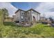 Spacious backyard with multiple patio areas, ample seating, manicured lawn, and mature landscaping at 5572 Fullerton Cir, Highlands Ranch, CO 80130