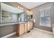 This bathroom has a large mirror, double sinks, oak cabinets, and tiled floors at 5572 Fullerton Cir, Highlands Ranch, CO 80130