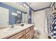This bathroom features a double sink vanity, a shower-tub combo, and blue-painted walls at 5572 Fullerton Cir, Highlands Ranch, CO 80130