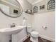 This half bathroom features a pedestal sink, a toilet, and decorative wall art at 5572 Fullerton Cir, Highlands Ranch, CO 80130