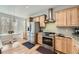Modern kitchen boasts stainless steel appliances, wooden cabinets and stone countertops at 5572 Fullerton Cir, Highlands Ranch, CO 80130