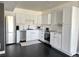 Modern basement kitchen with white cabinets, stainless steel appliances, and dark hardwood floors at 15601 W Eureka Ave, Morrison, CO 80465