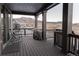 Covered deck with rocking chairs and a grill, overlooking the mountains at 15601 W Eureka Ave, Morrison, CO 80465