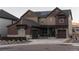 Two-story home with brown siding, stone accents, and solar panels at 15601 W Eureka Ave, Morrison, CO 80465