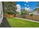 Large grassy backyard with a wooden fence offering privacy and space for outdoor activities and gardening at 8357 Dudley Ct, Arvada, CO 80005