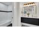 Beautiful bathroom with modern double vanity, black accenting and unique tile in the shower at 8357 Dudley Ct, Arvada, CO 80005