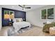 Modern bedroom featuring a stylish accent wall, hardwood floors, and a ceiling fan at 8357 Dudley Ct, Arvada, CO 80005