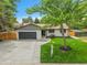 Charming home featuring a well-manicured lawn, gray garage door, and inviting front entrance with ample parking at 8357 Dudley Ct, Arvada, CO 80005