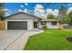 Charming single-story home featuring a large driveway, two-car garage, and inviting lawn at 8357 Dudley Ct, Arvada, CO 80005