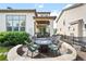 Charming backyard featuring a stone fire pit, lush greenery, and well-manicured landscaping at 15205 W Baker Ave, Lakewood, CO 80228