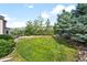 A vast backyard showcasing lush green lawn and a variety of mature trees at 15205 W Baker Ave, Lakewood, CO 80228