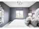 Stylish bedroom with gray accent wall, unique headboard, and plenty of natural light at 15205 W Baker Ave, Lakewood, CO 80228