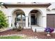 Inviting front porch showcasing arched entryways, a bench, decorative plants, and manicured garden beds at 15205 W Baker Ave, Lakewood, CO 80228