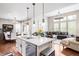 Open kitchen with a large island, sink, and stainless steel appliances adjacent to the living area at 15205 W Baker Ave, Lakewood, CO 80228