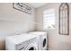 Efficient laundry room featuring modern appliances and ample shelving at 15205 W Baker Ave, Lakewood, CO 80228