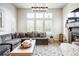 Bright living room featuring a fireplace, a large sectional sofa, and floor-to-ceiling windows with white shutters at 15205 W Baker Ave, Lakewood, CO 80228