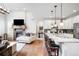 Open-concept living space with a kitchen island, a fireplace, hardwood floors, and stylish decor at 15205 W Baker Ave, Lakewood, CO 80228
