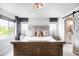 Main bedroom featuring neutral tones, large windows, and barn door to main bathroom at 15205 W Baker Ave, Lakewood, CO 80228