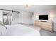 Spacious main bedroom with a sliding barn door and a large TV at 15205 W Baker Ave, Lakewood, CO 80228