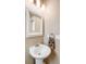 Cozy powder room with pedestal sink, decorative mirror, and modern towel ring at 15205 W Baker Ave, Lakewood, CO 80228