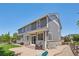 Large backyard with gray siding, a patio area for dining, and a well-manicured lawn at 8677 S Buchanan Way, Aurora, CO 80016