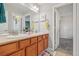Well-lit bathroom featuring a double vanity, neutral color palette, and tiled flooring at 8677 S Buchanan Way, Aurora, CO 80016