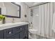 Modern bathroom featuring a dark vanity, patterned tile flooring, and walk-in shower at 8677 S Buchanan Way, Aurora, CO 80016