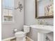 Powder room with pedestal sink and decorative mirror at 8677 S Buchanan Way, Aurora, CO 80016