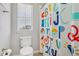 Bright bathroom showcasing a toilet, window, and alphabet shower curtain at 8677 S Buchanan Way, Aurora, CO 80016