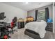 Bedroom features a bed, desk, gaming chair, dark curtains, and neutral carpet at 8677 S Buchanan Way, Aurora, CO 80016