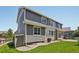 Two-story home with gray siding, white trim, a well-manicured lawn, and a small stone border at 8677 S Buchanan Way, Aurora, CO 80016