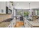 Open kitchen and dining area with granite countertops, stainless appliances, and view to the backyard at 8677 S Buchanan Way, Aurora, CO 80016